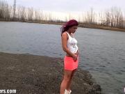 Девушка развлекается возле реки
